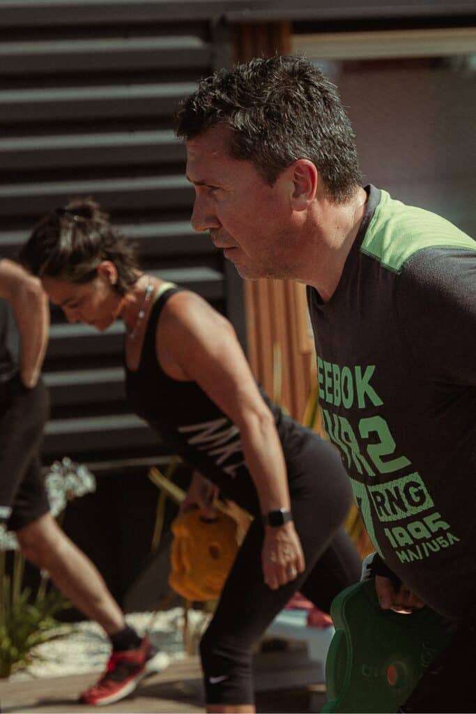 Deadlift : Exercice intense d'haltères lors d'une session fitness. Homme en t-shirt Reebok (WR2) et femme en Nike effectuant des soulevés de terre (haltères) lors d'un entraînement fitness extérieur.